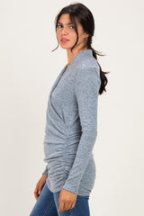 woman wearing a gray long sleeve shirt with gathered detailing and a relaxed fit, styled with blue jeans
