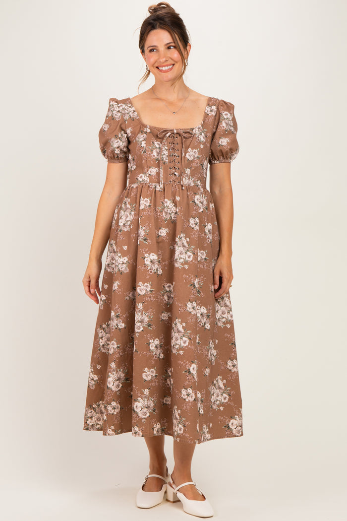 woman wearing a brown floral print maternity dress with puff sleeves and a square neckline, showing her baby bump