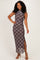 woman wearing a brown plaid maxi dress with a high neckline and side slit, smiling and posing against a neutral background