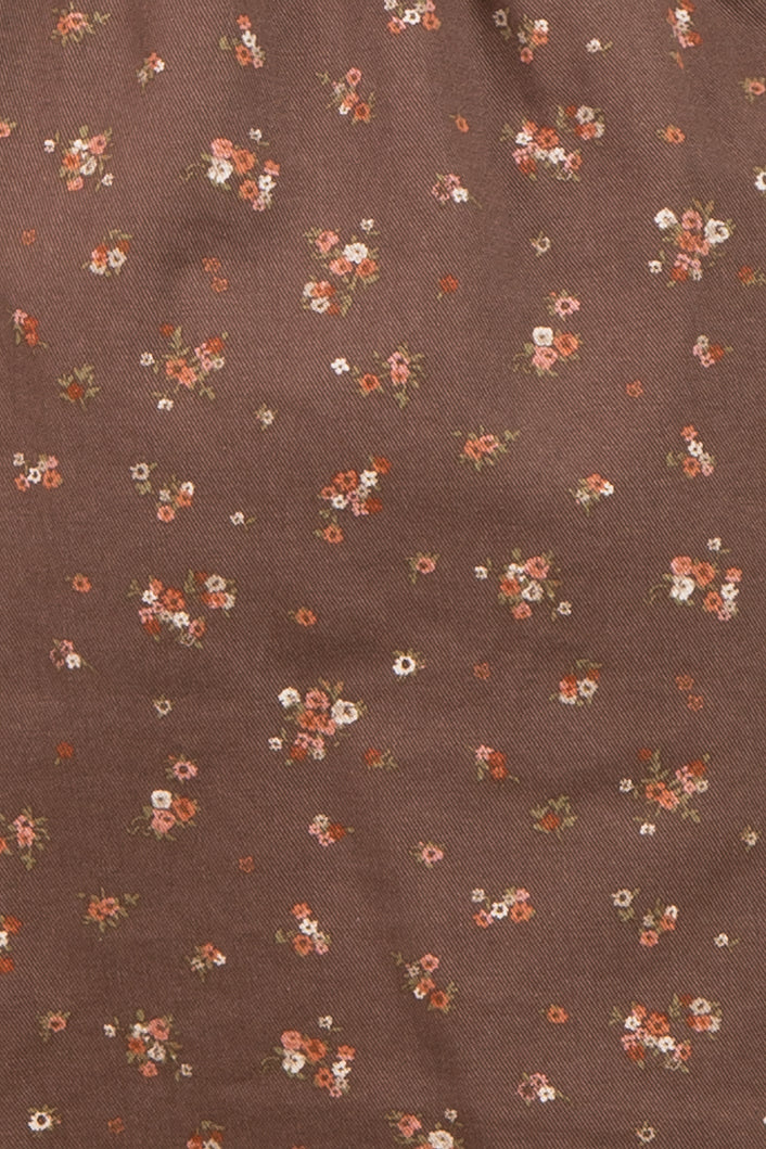 brown maternity wear fabric with small floral patterns in shades of pink, orange, and white