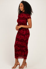 woman wearing a burgundy lace midi dress with short sleeves and floral pattern, standing sideways