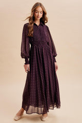 woman wearing a dark purple long sleeve maxi dress with white polka dots and a pleated bodice