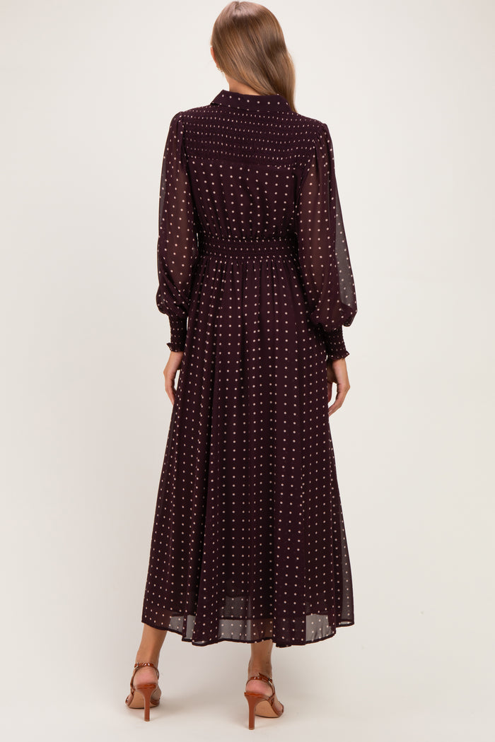 woman wearing a burgundy long sleeve maternity dress with white polka dots, showing the back view and a flowing skirt