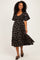 woman wearing a black floral midi dress with puff sleeves and a cinched waist