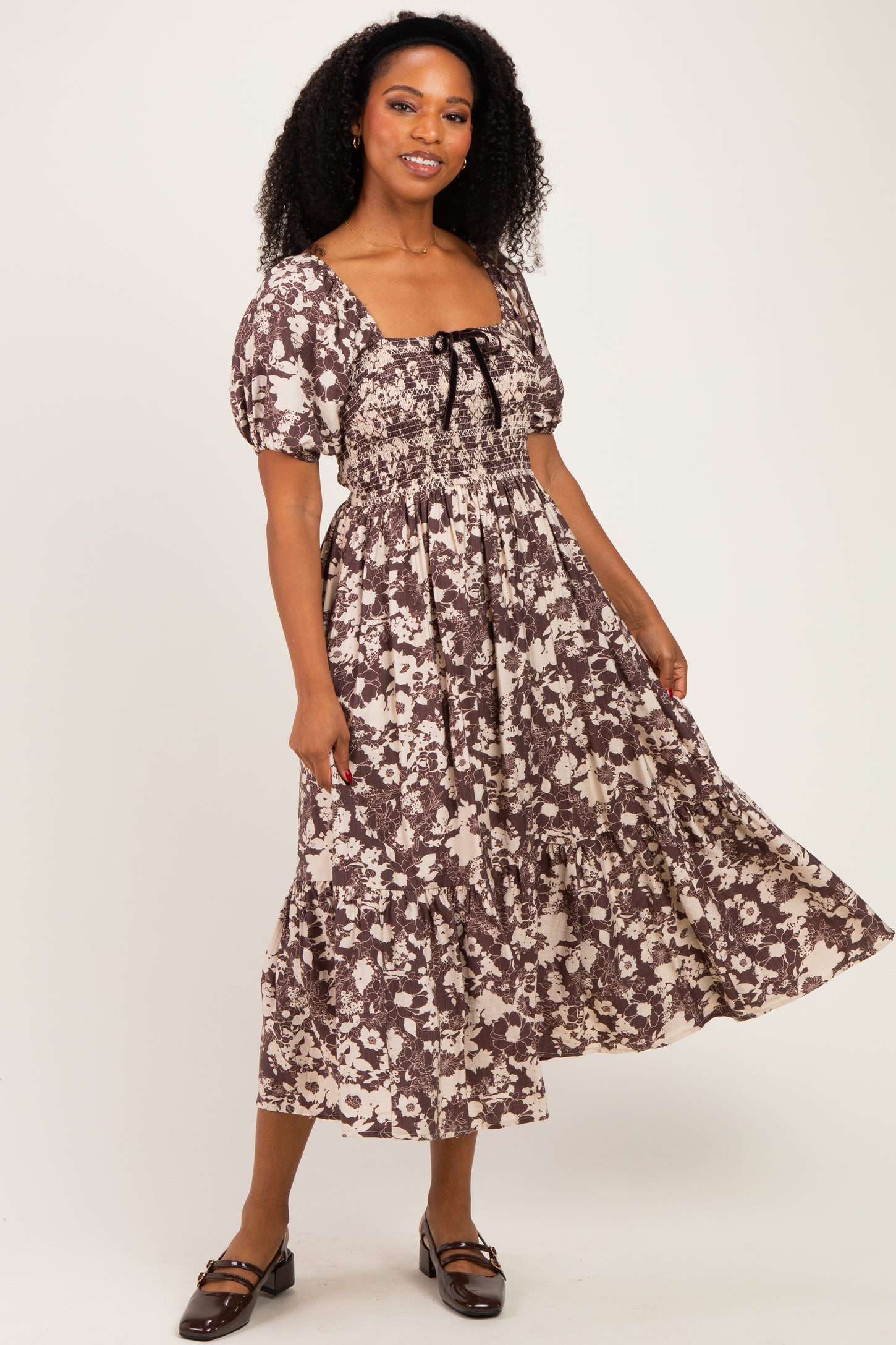 woman wearing a brown and cream floral midi dress with puff sleeves and a square neckline