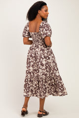 woman wearing a brown and cream floral smocked midi dress with puff sleeves and tiered skirt, shown from the back
