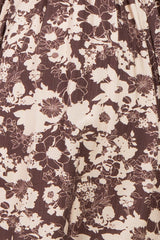 close-up of a floral print brown dress with beige flowers and intricate detailing