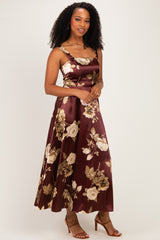 woman wearing a burgundy satin floral dress with a square neckline and spaghetti straps