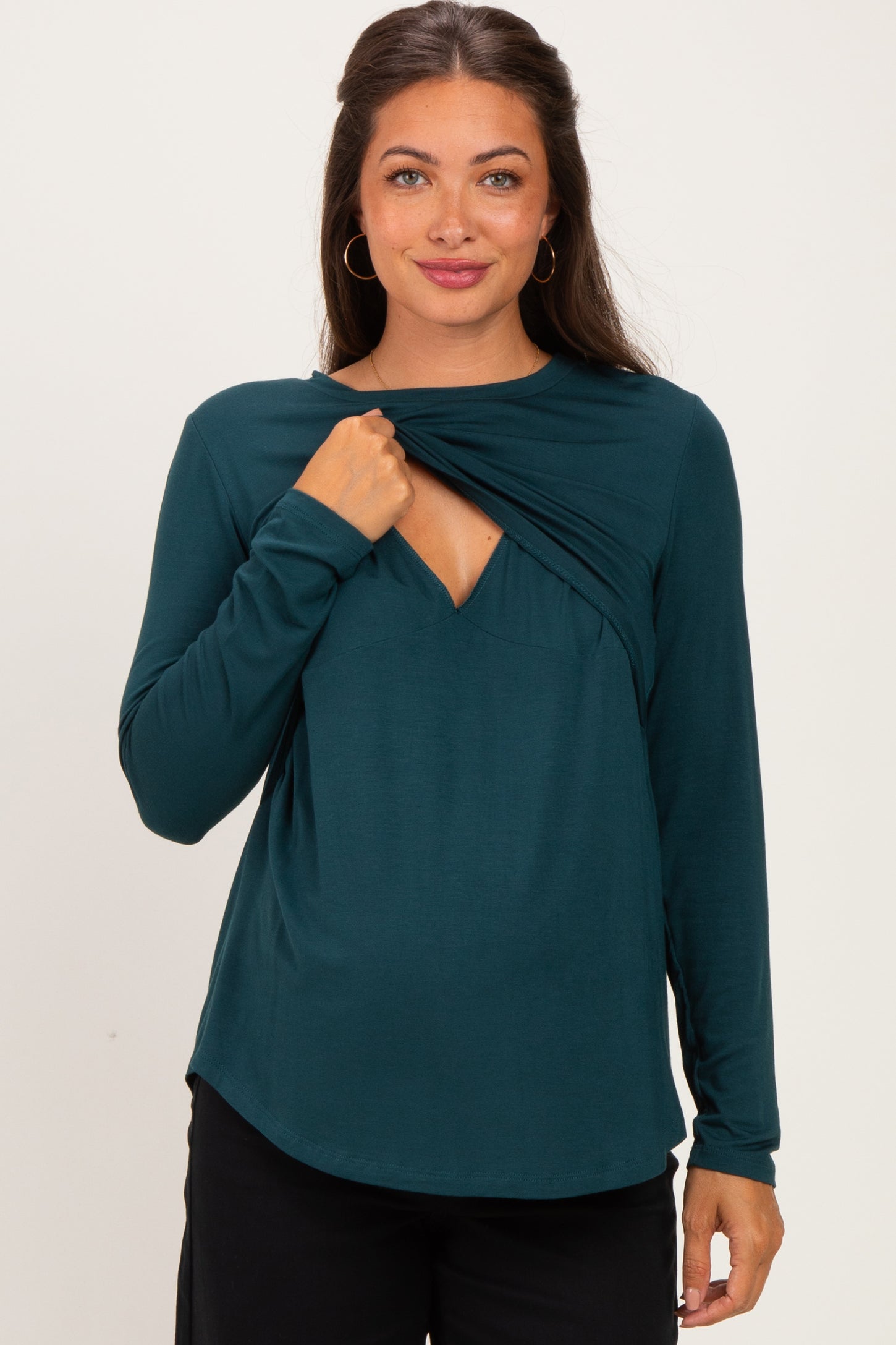 woman wearing a dark teal long sleeve maternity top with a crossover neckline and ruching detail