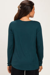 woman wearing a dark teal long sleeve maternity top, showing the back view and a smooth silhouette