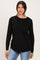 woman wearing a black long sleeve top with a layered design and paired with light blue jeans
