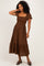 woman wearing a brown plaid midi dress with short puff sleeves and a tiered ruffle hem
