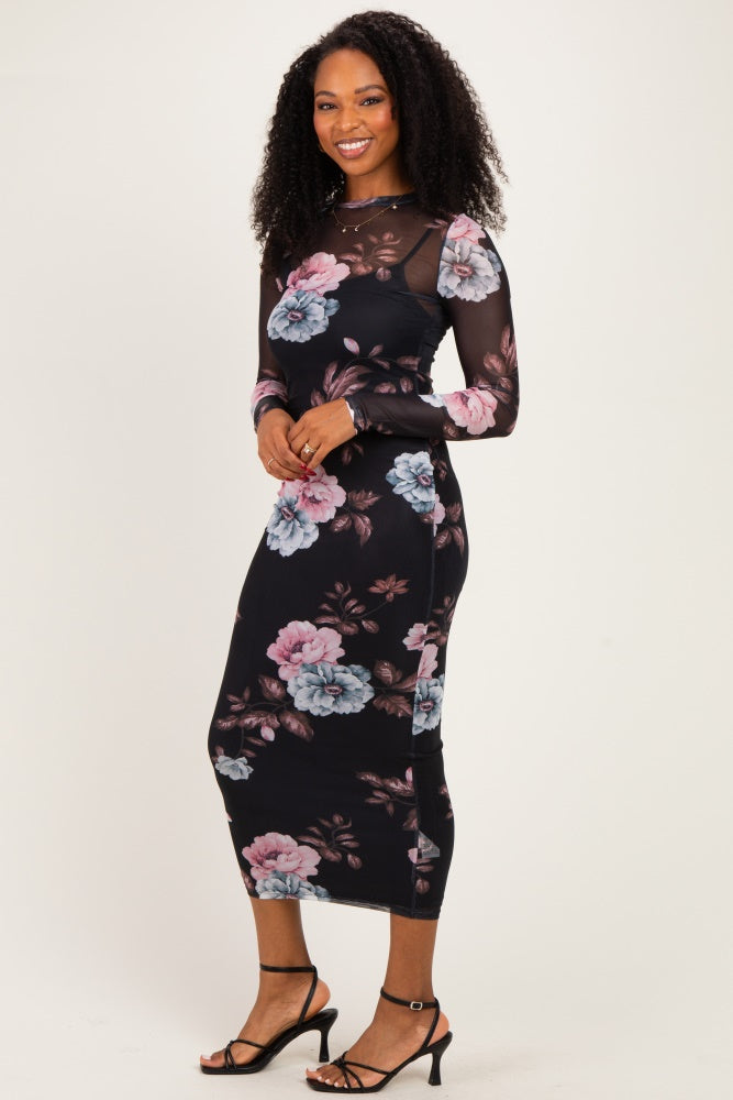 woman wearing a black floral long sleeve midi dress with sheer sleeves and fitted silhouette