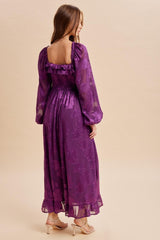 woman wearing a purple floral maxi dress with puff sleeves and a smocked back, shown from the back