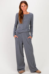 woman wearing a gray long sleeve henley top and matching wide-leg pants with side pockets