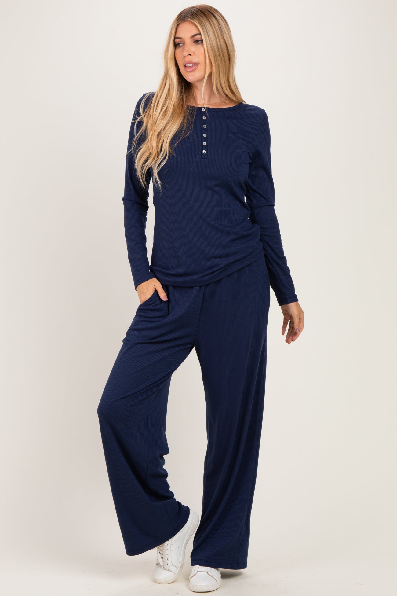 woman wearing a navy blue long sleeve top with buttons and matching wide-leg pants, styled casually with pockets