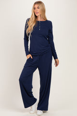 woman wearing a navy blue long sleeve top with buttons and matching wide-leg pants, styled casually with pockets