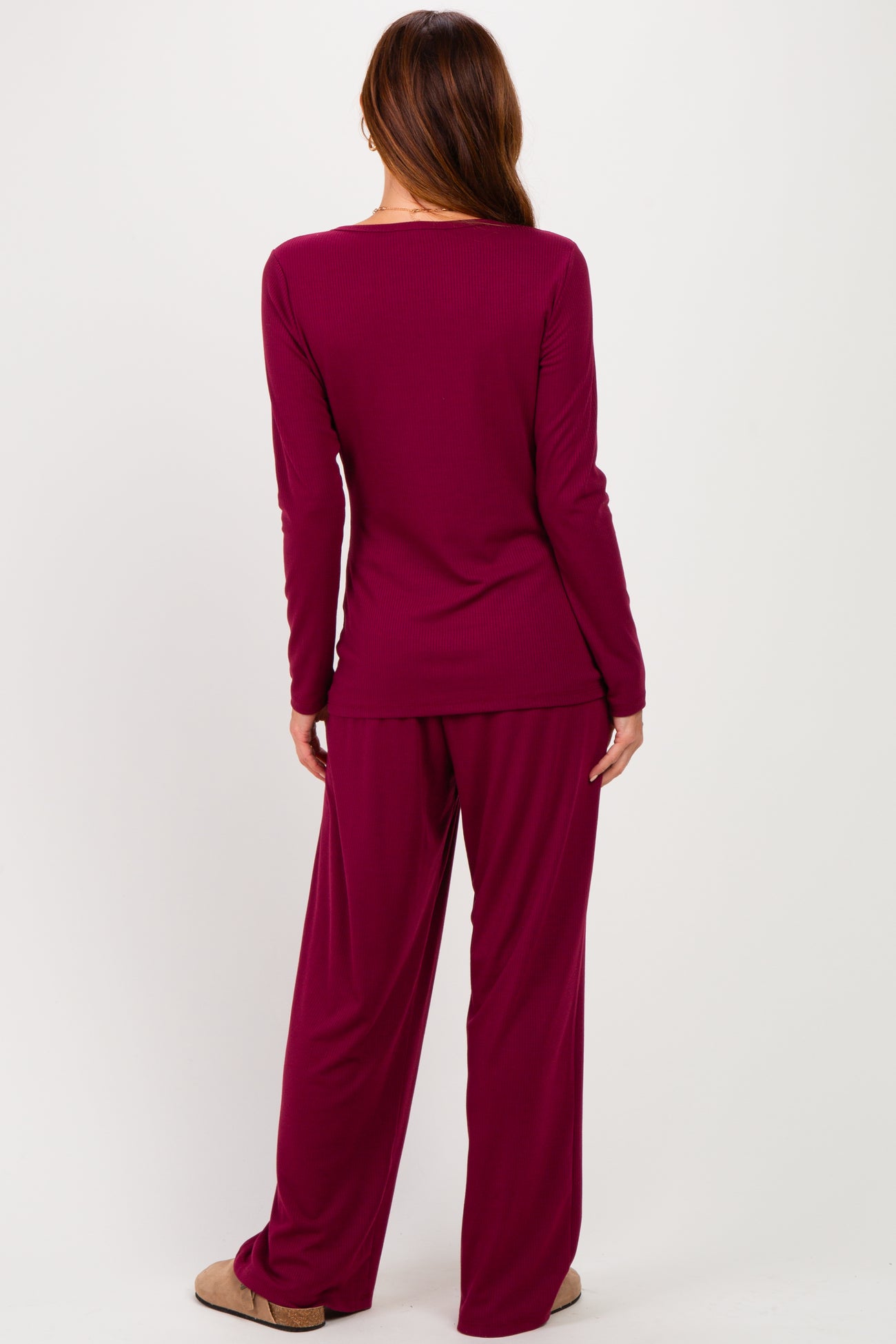 woman wearing a burgundy long sleeve top and matching wide-leg pants, seen from the back