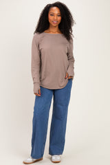 woman wearing a taupe long sleeve top with side ruching and high-waisted blue wide-leg jeans