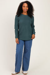 woman wearing a dark green textured long sleeve sweater and wide leg denim jeans