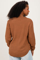 woman wearing a brown textured knit sweater with a loose fit and dropped shoulders, viewed from the back