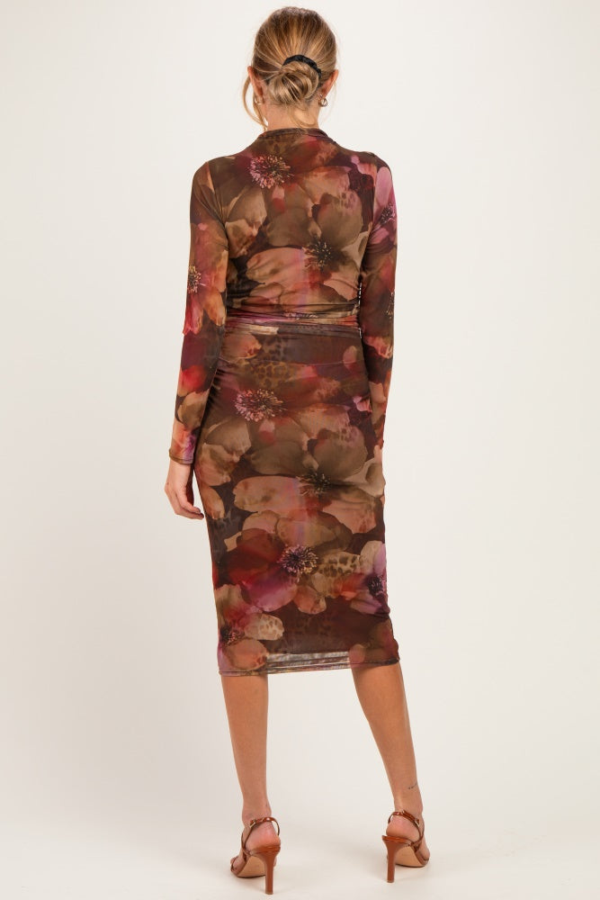woman wearing a floral print long sleeve maternity dress that hugs the body and falls to mid-calf