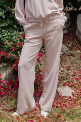 woman wearing light pink wide-leg lounge pants with an elastic waistband and side pockets