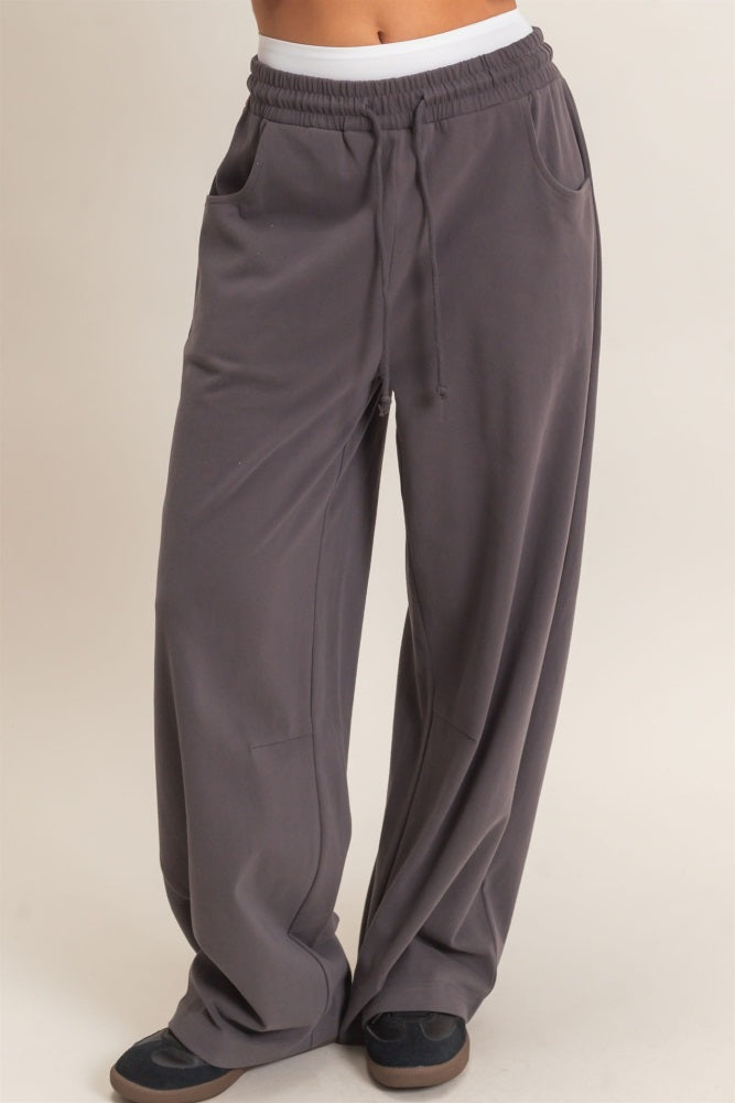 woman wearing dark gray wide-leg sweatpants with an elastic waistband and pockets
