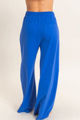 woman wearing bright blue wide-leg pants with an elastic waistband and back pocket