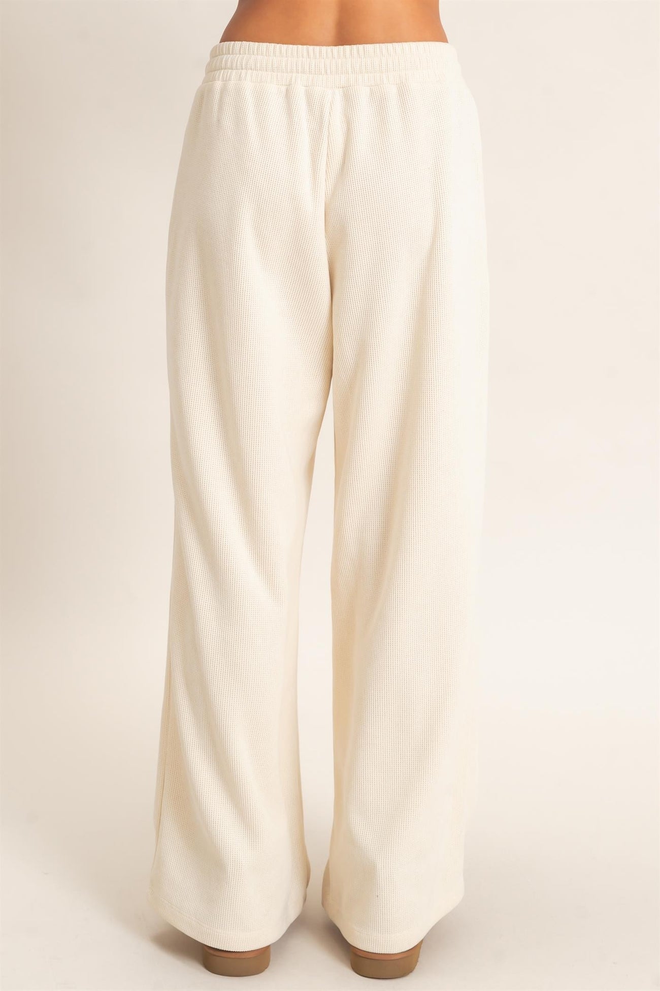 woman wearing cream wide-leg lounge pants with an elastic waistband