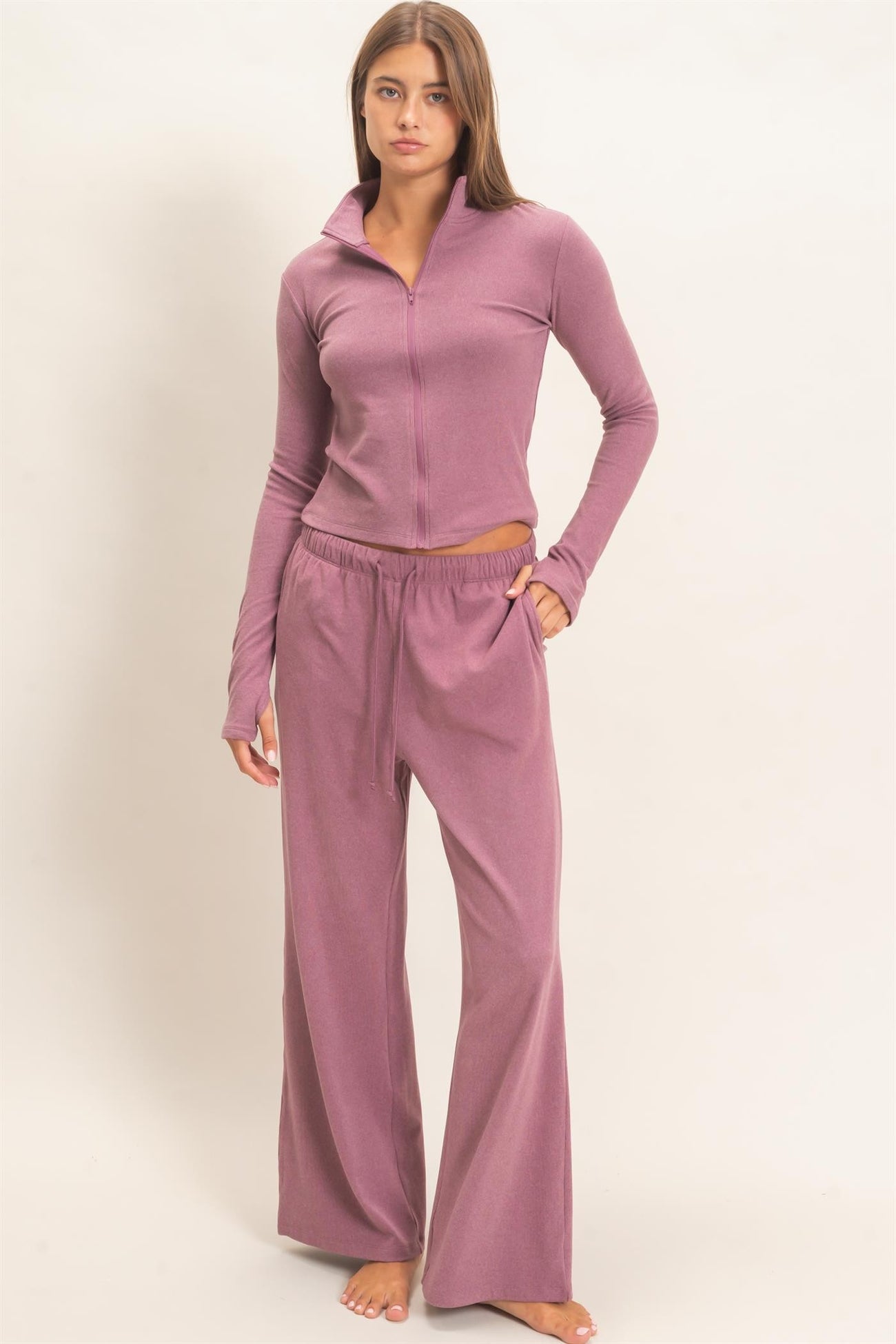 woman wearing a dusty rose zip-up long sleeve top and matching wide-leg lounge pants