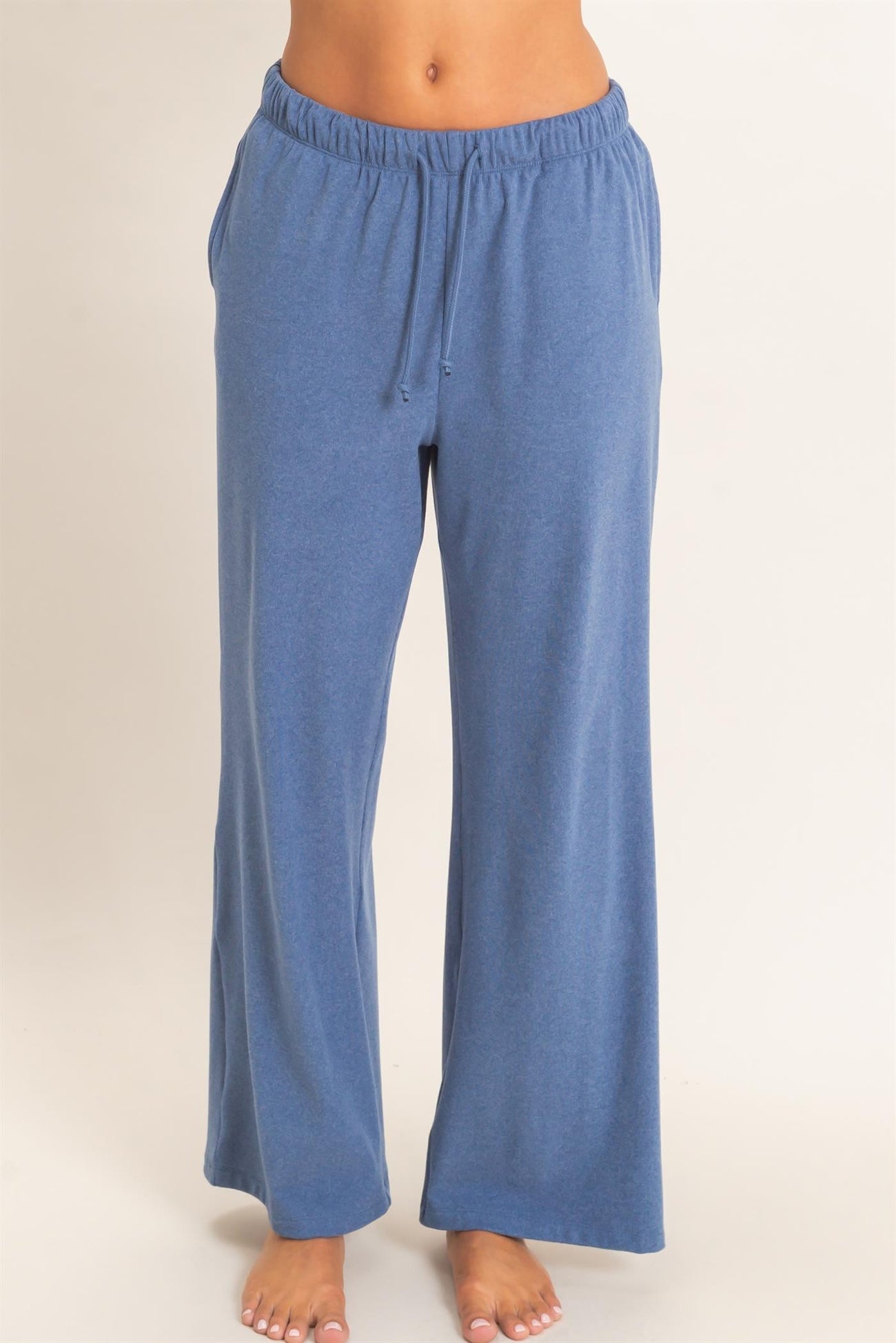 woman wearing a pair of loose-fitting blue lounge pants with a drawstring waist and side pockets