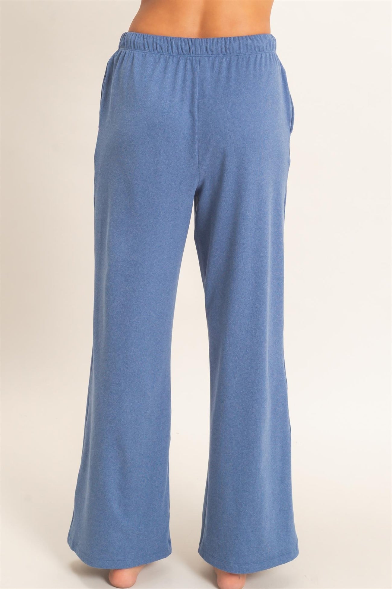 woman wearing blue wide-leg lounge pants from the back, featuring an elastic waistband and side pockets