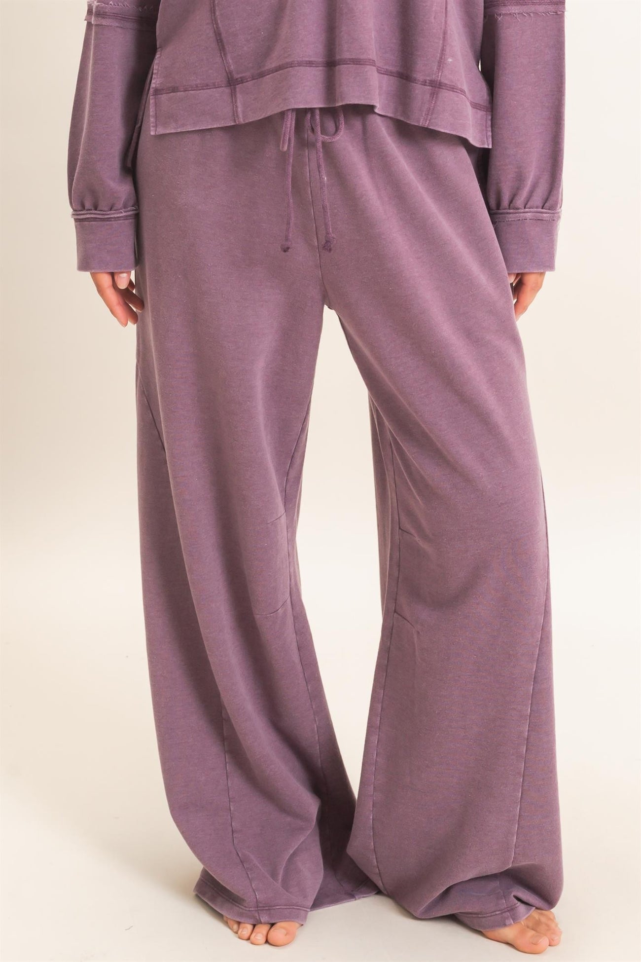woman wearing purple wide leg lounge pants with a drawstring waist and a relaxed fit