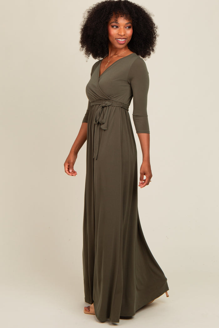 woman wearing a long olive green wrap dress with three-quarter sleeves and a tied waist