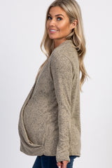 woman wearing a tan maternity cardigan with a draped front, showcasing her baby bump