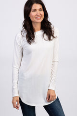 woman wearing a white long sleeve waffle knit tunic top and blue jeans