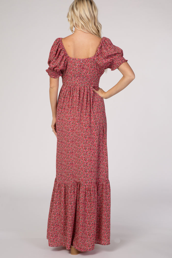 Back view of a blonde woman wearing a pink floral puff sleeve maxi dress with a tiered skirt