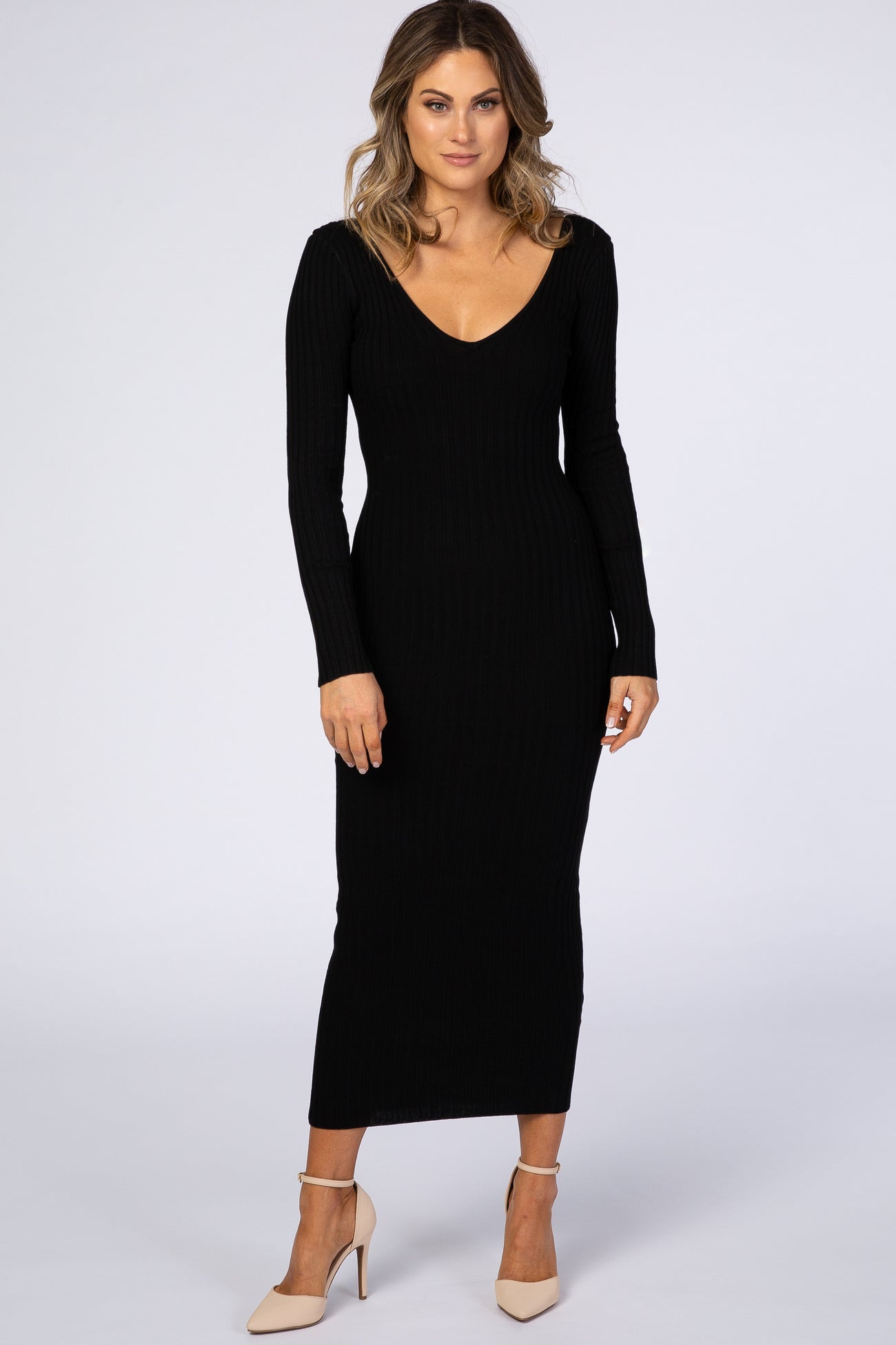 woman wearing a fitted black ribbed long sleeve maxi dress with a plunging neckline