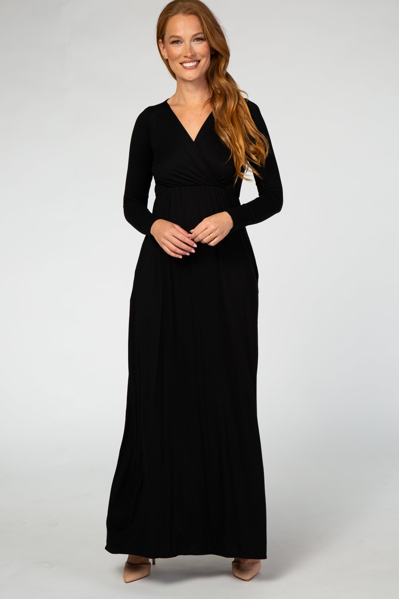 woman wearing a black long sleeve maxi dress with a wrap bodice and pockets