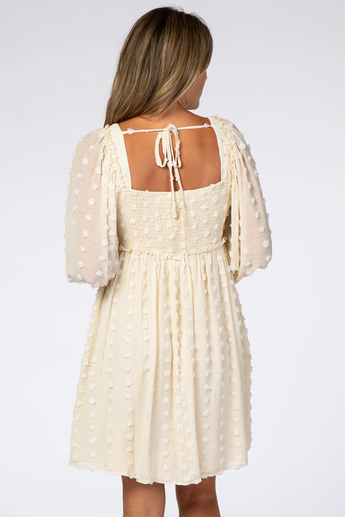 woman wearing a cream puff sleeve dress with a smocked bodice and back tie detail