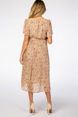 woman wearing a beige floral maternity dress with short sleeves and pleated skirt, showing her back