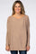 woman wearing a beige oversized sweater with long sleeves and a wide neckline, styled with dark blue jeans