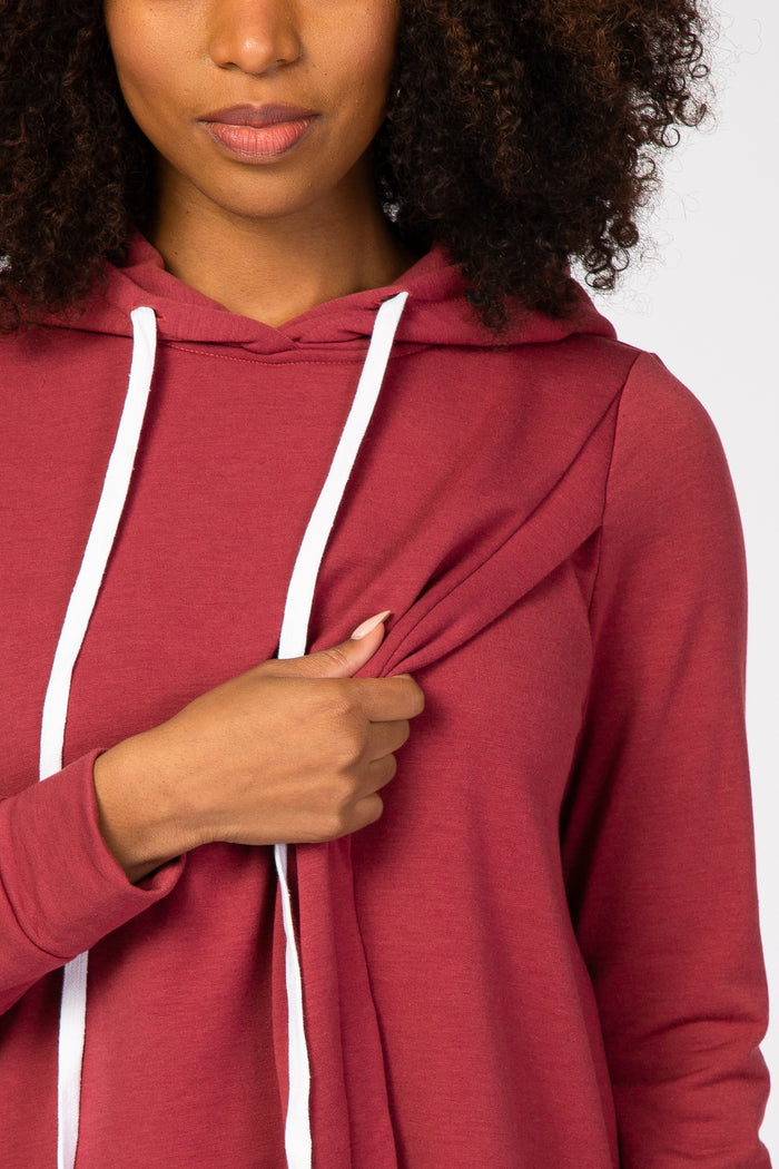 woman wearing a maroon long sleeve hooded top with drawstrings and a stylish front knot detail