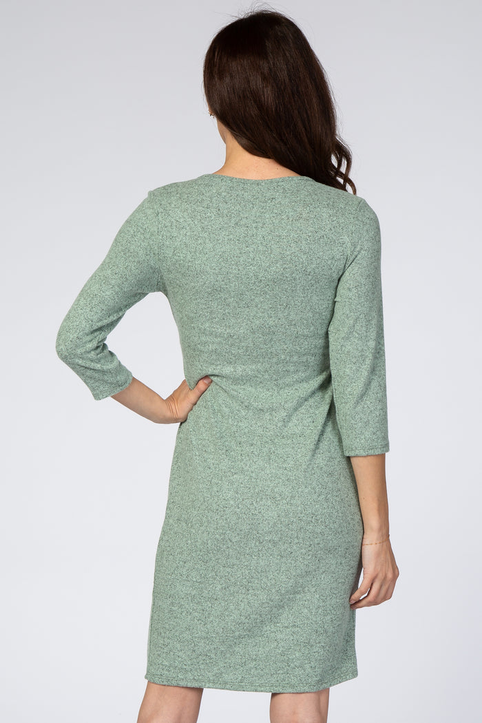 woman wearing a light green three-quarter sleeve dress, seen from the back