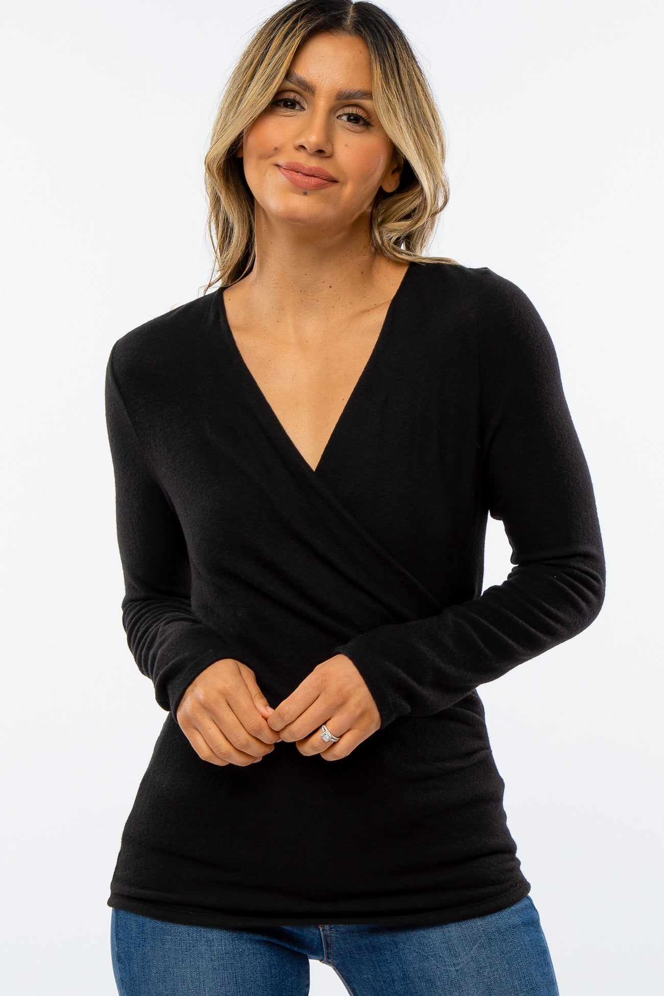 woman wearing a black long sleeve wrap top and smiling