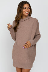 woman wearing a taupe cowl neck maternity sweater dress with a visible baby bump