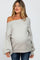 woman wearing a light gray off-shoulder maternity sweater with balloon sleeves and a visible baby bump