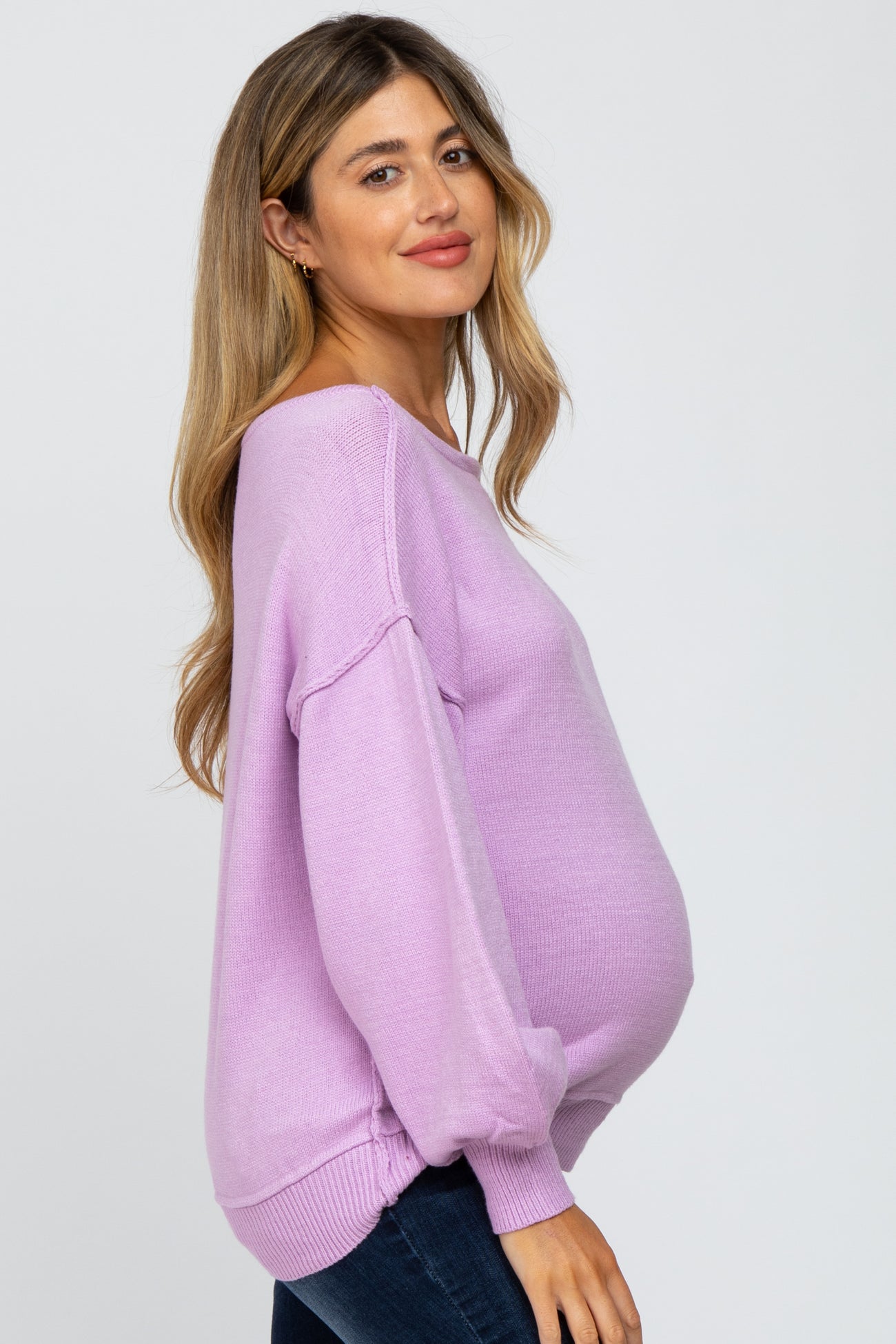 woman wearing a light purple maternity sweater with a relaxed fit and visible baby bump