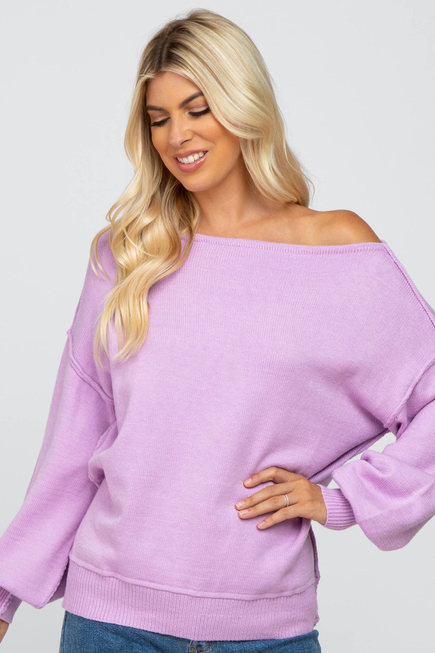 woman wearing a lavender off-shoulder sweater with long sleeves and a relaxed fit